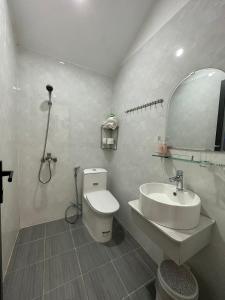 uma casa de banho com um lavatório, um WC e um espelho. em Út Thảo 2 em Da Lat