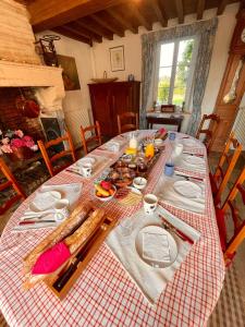 una mesa con un mantel a cuadros rojo y blanco en Ferme fortifiée d Enguenard, en Formigny