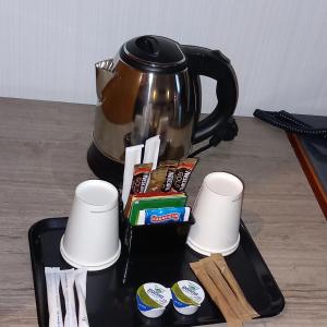ein Tablett mit einer Teekanne und Tassen auf einem Tisch in der Unterkunft Novotel Roma Eur in Rom