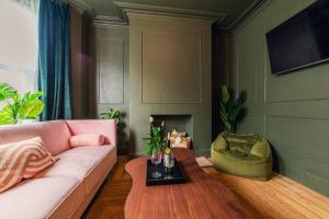 uma sala de estar com um sofá rosa e uma mesa em Kim's City Escape em Cardiff