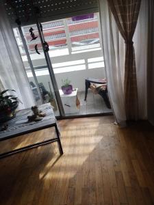 een woonkamer met een tafel en een groot raam bij Loft Quilmes in Quilmes