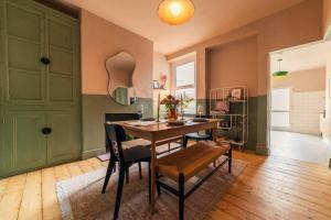 a dining room with a wooden table and chairs at Kim's City Escape in Cardiff