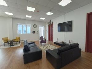 ein Wohnzimmer mit 2 Sofas und einem TV in der Unterkunft Albergaria Formosa in Faro