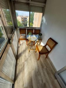 Cette chambre comprend une table, des chaises et des fenêtres. dans l'établissement Alia, à Madrid