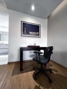 una oficina con escritorio y silla en una habitación en Quinta Dorada Hotel & Suites, en Saltillo