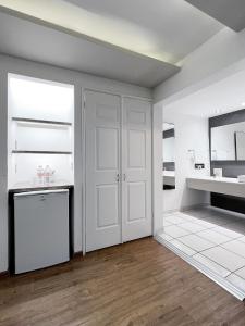 a kitchen with white walls and a white refrigerator at Quinta Dorada Hotel & Suites in Saltillo