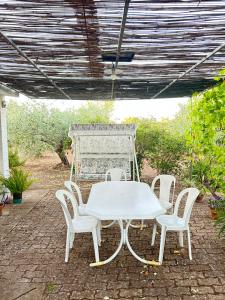 un tavolo bianco e sedie su un patio di Domo Austinu - Abbasanta ad Abbasanta