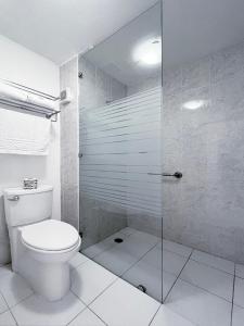 a bathroom with a toilet and a glass shower at Quinta Dorada Hotel & Suites in Saltillo