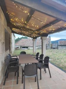 un patio con tavolo, sedie e luci di A Rebeirana a Mondariz