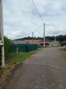 an empty road next to a green fence at A Rebeirana in Mondariz