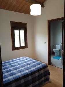 una camera con un letto con una coperta a scacchi blu e bianca di A Rebeirana a Mondariz
