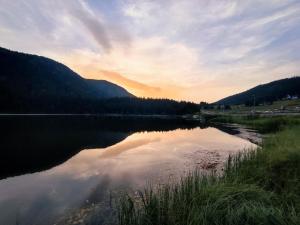 a view of a lake at sunset with trees and mountains at VIG 2 in Njegovuđa