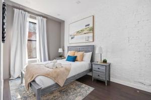a bedroom with a bed and a white brick wall at SWJ 3rd - Sleeps 7,Close to LGA,Times Sq in 25 min in New York