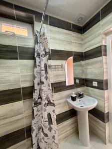 Un baño con cortina de ducha y lavabo. en Hotel ATAUUL, en Kaji-Say
