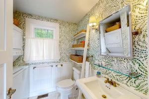 een badkamer met een toilet, een wastafel en een raam bij Periwinkle Cottage in Westport