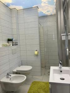 a white bathroom with a toilet and a sink at KAISER'S Freundschaft in Klagenfurt