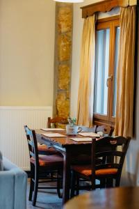 uma sala de jantar com uma mesa de madeira e cadeiras em Apolithomeno Dasos Holiday Villas em Lefkimmi