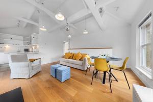 ein Wohnzimmer mit einem Tisch, Stühlen und einem Sofa in der Unterkunft Flourish Apartments - The Annex - Dulwich Village in London