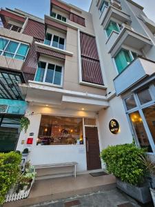 - un bâtiment blanc avec un restaurant en face dans l'établissement Habitat Hotel, à Chiang Mai