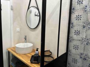 ein Bad mit einem Waschbecken und einem Spiegel in der Unterkunft Le repaire de la Vierge bohème vue mer in Cassis