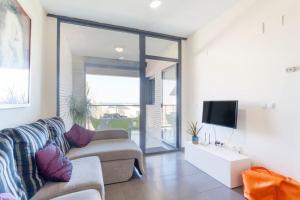a living room with a couch and a tv at Confortable Beach Appartment with Views to the Sea in Puzol