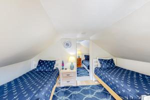 een slaapkamer op zolder met 2 bedden en een spiegel bij Seaside Cottage in Bristol