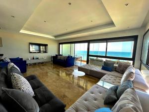 uma sala de estar com dois sofás e vista para o oceano em Appart de Luxe front de mer Prestigia Plage des Nations em Salé