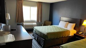 Un pat sau paturi într-o cameră la Colby Inn and Suites