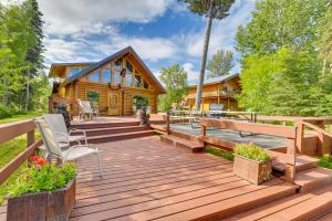 a wooden deck with chairs and a log cabin at Soldotna Fishing Lodges with Dock on Kenai River! in Sterling