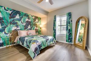 a bedroom with a bed with a tropical wallpaper at Orlando Golden Girls Retreat Prime Location! in Orlando