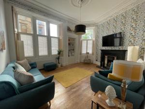 a living room with two blue couches and a fireplace at Stunning West End Flat! in Glasgow