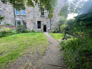 un vieux bâtiment en pierre avec un chemin menant à une cour dans l'établissement Stunning West End Flat!, à Glasgow