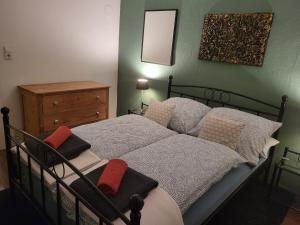 ein Schlafzimmer mit einem Bett mit Kissen und einem Spiegel in der Unterkunft Ferienwohnung Bohn in Kappel-Grafenhausen