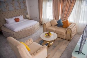 MONDEESTARS LUXURY HOME في إيبادان: غرفة معيشة مع سرير وأريكة وكراسي