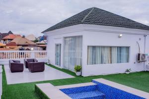 a white house with two chairs and a patio at MONDEESTARS LUXURY HOME in Ibadan