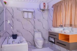 a bathroom with a toilet and a sink at MONDEESTARS LUXURY HOME in Ibadan