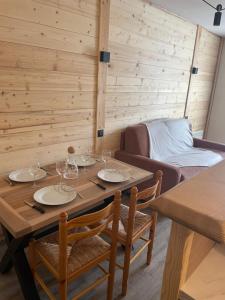 a dining room with a table and chairs and a couch at Studio tout confort in Barcelonnette