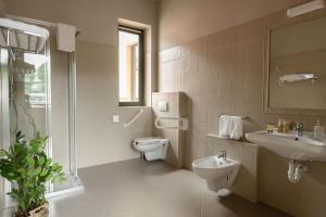 uma casa de banho com um WC, um lavatório e um espelho. em Trepiasì em Cortemilia