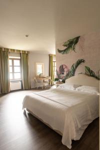 um quarto com uma grande cama branca num quarto em Trepiasì em Cortemilia