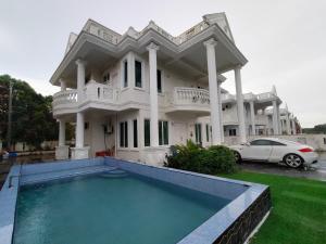 a large white house with a swimming pool in front of it at RoofTop Villa in Malacca
