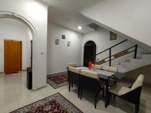 a dining room with a table and chairs and a staircase at RoofTop Villa in Malacca