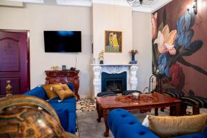 a living room with a blue couch and a fireplace at Zielony Kompleks Dwór Ostoya in Jasionka