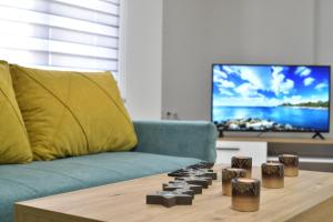 a living room with a couch and a video game controller at Apartmani Filipović in Vrdnik