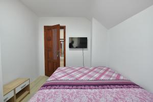 a bedroom with a bed and a tv on the wall at Apartmani Filipović in Vrdnik