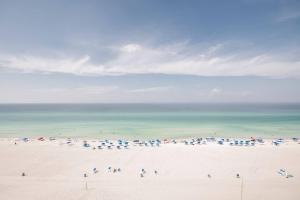 a beach with a bunch of umbrellas and the ocean at Sunbird Sunsets in Panama City Beach +12 photos