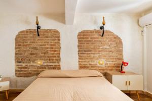 ein Schlafzimmer mit 2 Ziegelwänden und einem Bett in der Unterkunft Monolocale "Duomo" in Messina