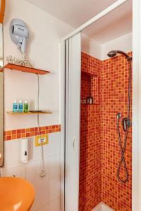 y baño con ducha y azulejos de color naranja. en Monolocale "Duomo", en Messina