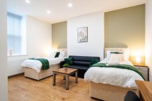 - une chambre avec deux lits et un canapé dans l'établissement Innovation House, à Burnley