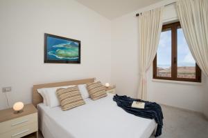 a bedroom with a white bed and a window at Old Charm - Seaview Apartment in La Maddalena