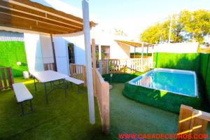 a patio with a pool and a table and chairs at Lodges de cedros in Setúbal